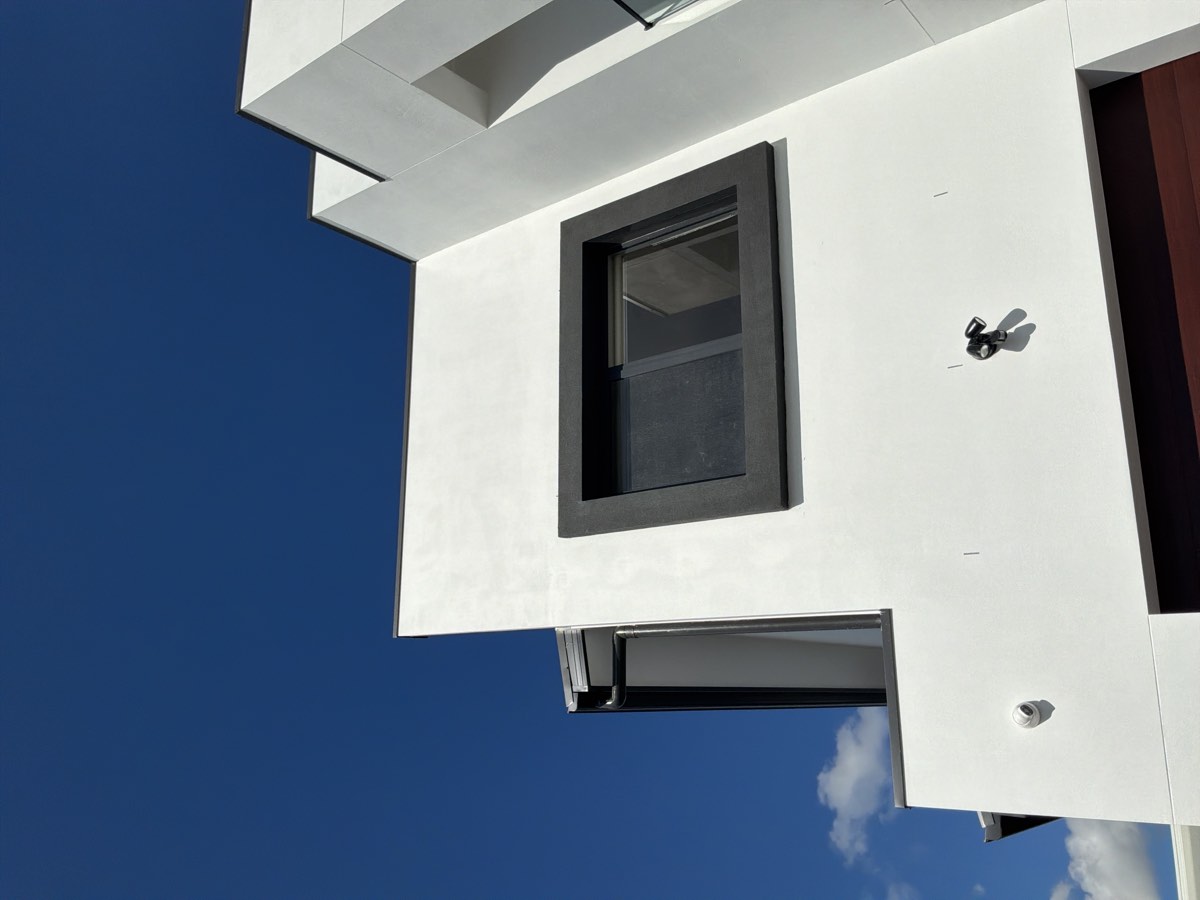 Insufficient or negative slope to parapet capping, recorded on a handover inspection in Riverstone